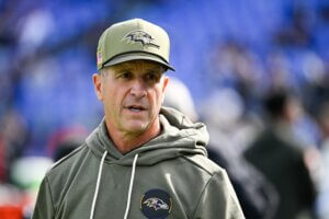 John Harbaugh stands and looks as Ravens coach.