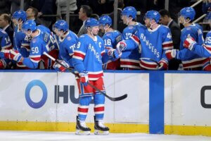 Rangers players dap up on the ice.