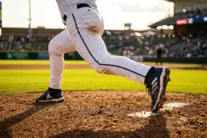 Baseball pitcher's leg planted on mound during delivery, emphasizing strength and foundation