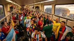 Crowded NJ Transit train full of World Cup fans heading to MetLife Stadium at sunset