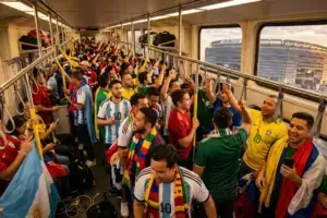 Crowded NJ Transit train full of World Cup fans heading to MetLife Stadium at sunset