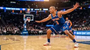 Knicks player in defensive stance under arena lights returning from injury for Eastern Conference Finals