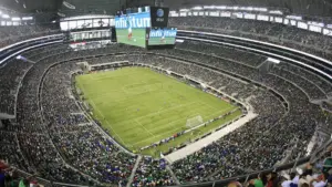 Inside AT&T Stadium during a soccer match with a large crowd.
