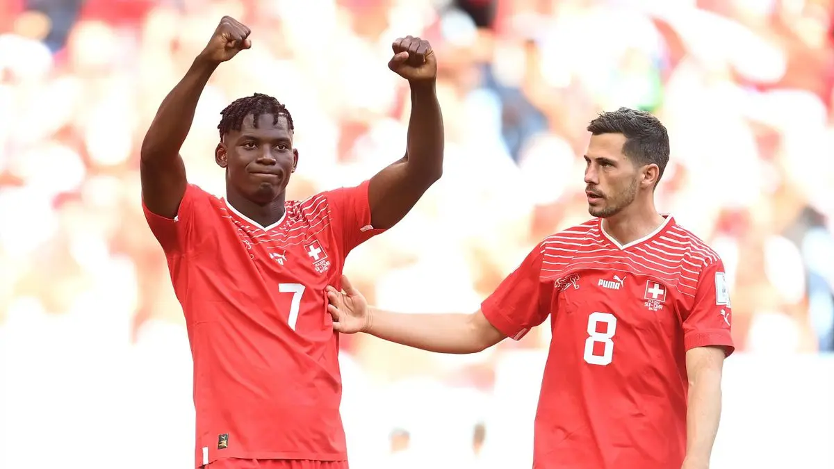 Breel Embolo celebrating in a Switzerland national team jersey during a match.