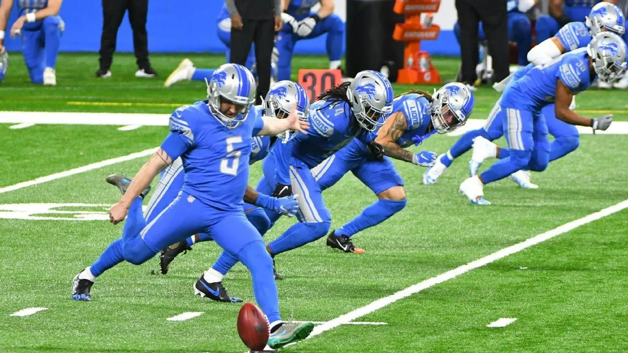 NFL player kicking a football during a game kickoff