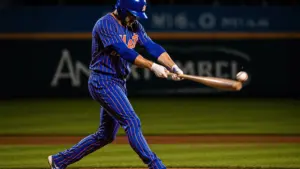 NY Mets player swinging bat during night game at Citi Field with stadium lights