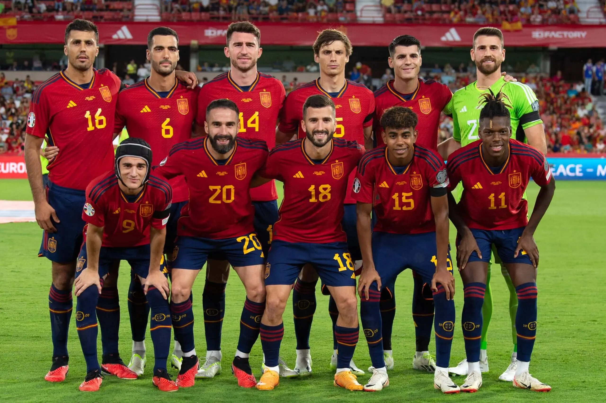 Spain national football team posing for a group photo in red and blue uniforms.