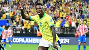 Vinicius Junior celebrating after scoring for Brazil in a football match.