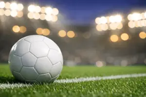Soccer ball on stadium field under bright lights for World Cup betting