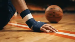 Basketball player's wrapped wrist on court symbolizing Jalen Brunson's recovery from surgery