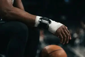 Basketball player's wrist in medical wrap symbolizing Jalen Brunson's summer surgery and recovery timeline