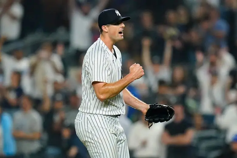 A jubilant pitcher in a pinstripe uniform celebrates on the mound.