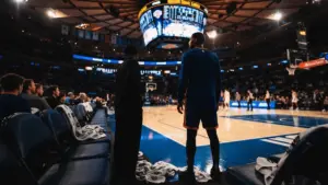 Knicks player silhouette at Madison Square Garden bench during NBA game with dramatic arena lighting
