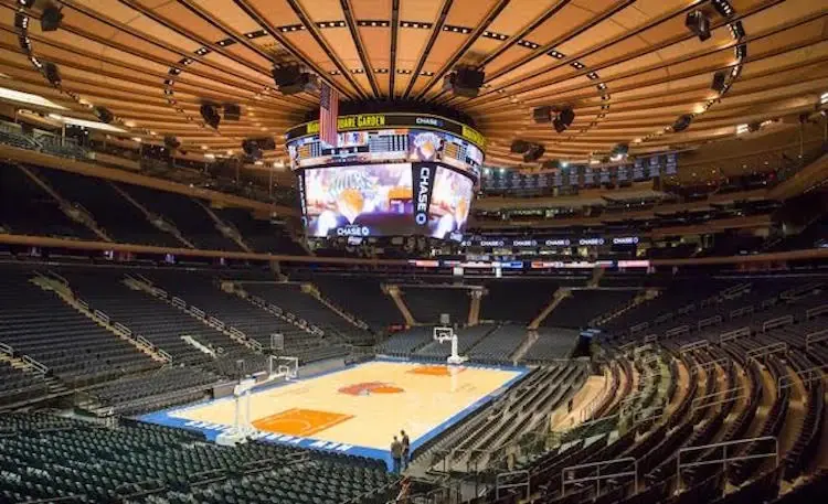 Interior view of Madison Square Garden basketball court with scoreboard and seating.