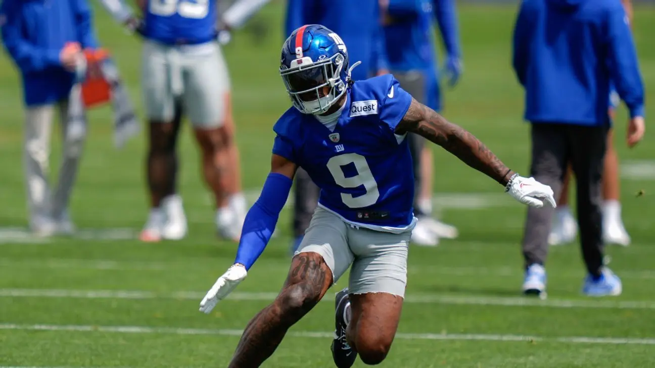 Football player in blue New York Giants jersey during training camp.