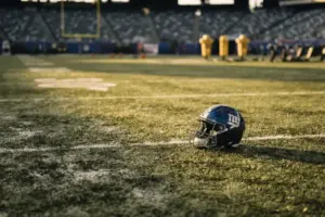 Empty Giants defensive line position with abandoned helmet on field showing roster depth crisis